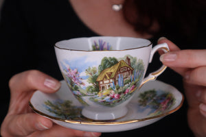 alt="woman's hands holding vintage royal vale cottage tea cup and saucer, available from Bramble and Fox UK hygge gifts and homewares"