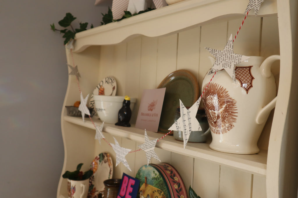 alt= "book and sheet music star garland decorating a dresser by Bramble and fox uk hygge shop"
