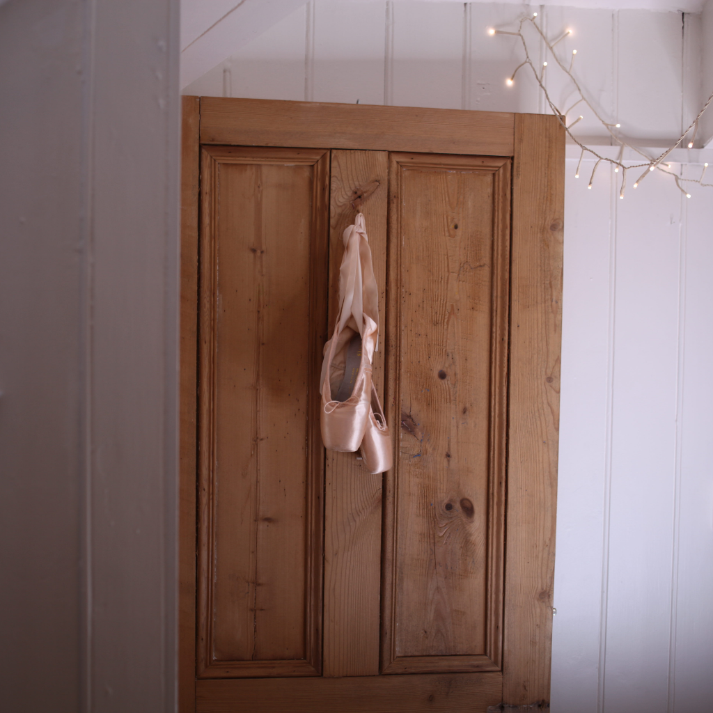 alt="bloch ballet pointe shoes hanging on back of wooden door available at bramble and fox uk hygge cottagecore homeware and gifts"