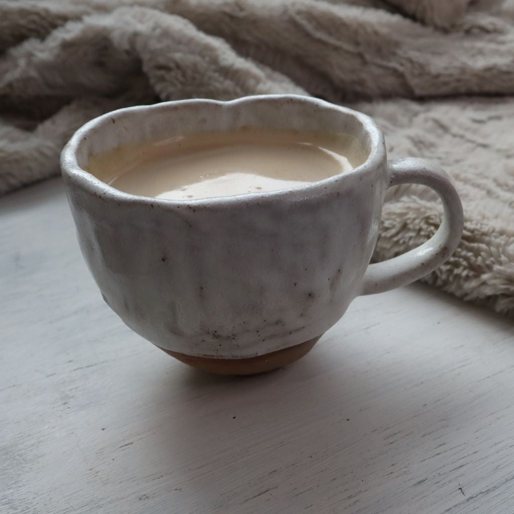 alt="handmade huggable coffee cup speckled with cream glaze. made by Clay Studio pottery and available at Bramble and Fox UK hygge homewares"