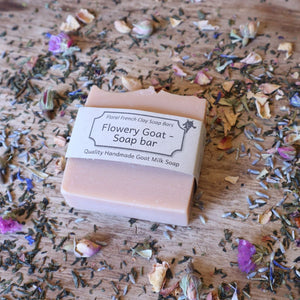 alt="flowery goat goap soap on a scattered flower petal background. available from bramble and fox uk hygge shop."