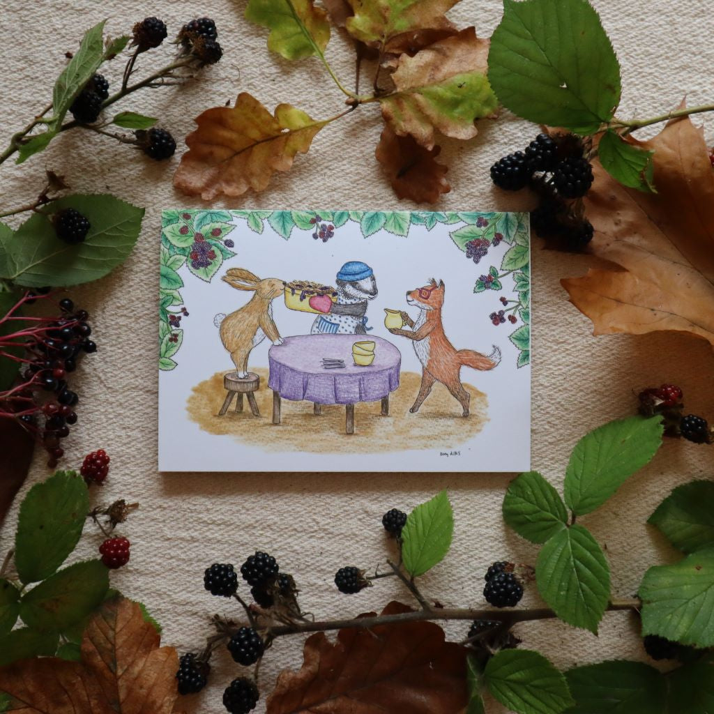 alt="Blackberry Crumble card by Kerry Dilks surrounded by Autumn leaves and berries. Kerry’s cosy illustrations are a gorgeous blend of Brambly Hedge meets Raymond Briggs, mixed with Janet Ahlberg and a dollop of Beatrix Potter. Available from Bramble & Fox UK hygge shop"