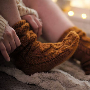 alt="woman's foot in Bibico mustard knitted socks. Available from Bramble and Fox UK hygge homeware and gifts"