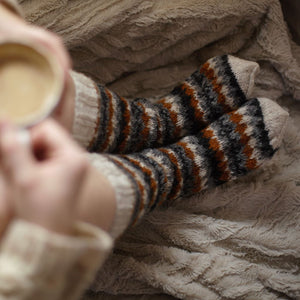 alt="woman's legs in cream, charcoal and mustard fair isle woollen socks, available from Bramble and Fox UK hygge homeware and gifts"
