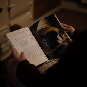 alt="woman's hands holding an open copy of Delia Smith's Christmas. Page shows a Christmas pudding. Book available from Bramble and Fox UK hygge homeware and gifts."