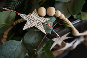 alt="close up of a paper star garland made from vintage books and sheet music by Bramble and Fox uk hygge gifts"